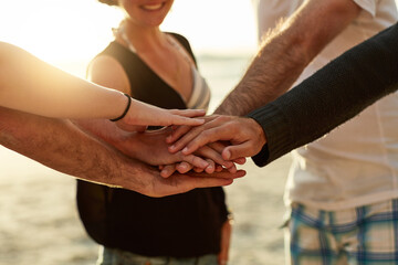 Group, friends and hands together for team building by beach on travel, vacation or break. People,...