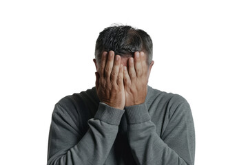 Fototapeta premium Man with his face partially obscured by his hands, showing a moment of overwhelm, on a white backdrop.