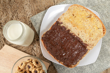 Bread with chocolate spread filling, milk and snack for breakfast	
