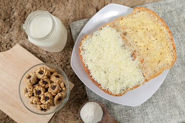 Bread with cheese, sweetened condensed milk, and butter. With white milk and snack on a table for breakfast	
