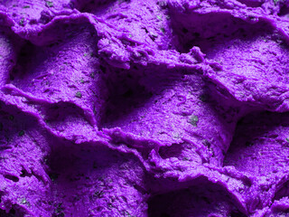 Frozen Lavender flavour gelato - full frame detail of sorbet. Close up of a violet surface texture of Ice cream filled with pieces of mixed flowers.