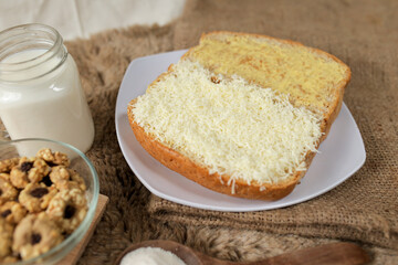 Bread with cheese, sweetened condensed milk, and butter. With white milk and snack on a table for breakfast	
