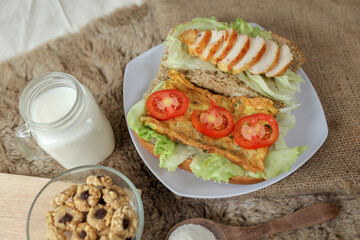 Big breakfast, bread, chicken slice, tomato, lettuce, smoked beef, egg, salad with milk. Bread sandwich fresh and healthy food meal lunch dinner breakfast slices of sandwiches.