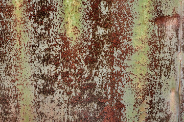 Backdrop of rusty surface of dark, brown, and orange hues. Detailed grunge rusted metal texture. Close-up of rust patterns, aged iron, scratched, worn, distressed areas, decay, corrosion details