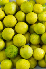 Yellow lime background. Close-up yellow lime texture with concepts of sour ingredients, Asian cuisine, organic, eating healthy, and cooking. Bright yellow food. Vertical texture background of limes.