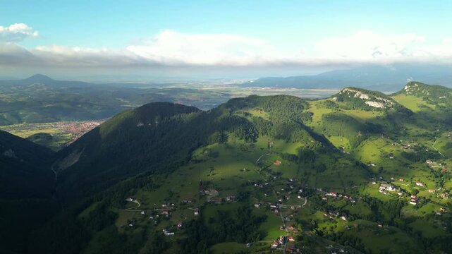 High angle flyover footage over the magnificent picturesque village of Magura in Brasov region of the Romanian Carpati mountains. Drone shot of the gem of romanian tourism on a green summer day.
