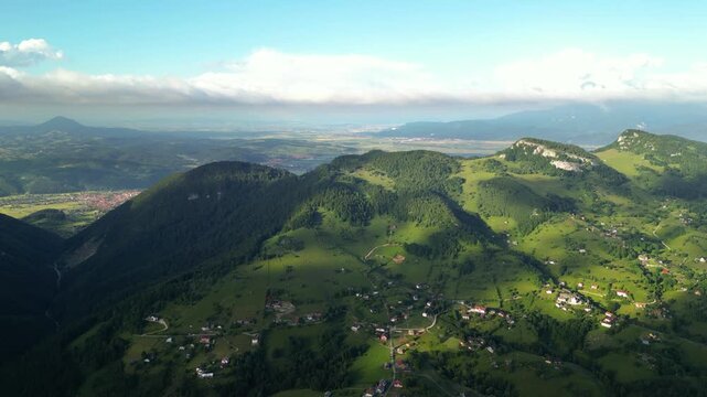 High angle flyover footage over the magnificent picturesque village of Magura in Brasov region of the Romanian Carpati mountains. Drone shot of the gem of romanian tourism on a green summer day.
