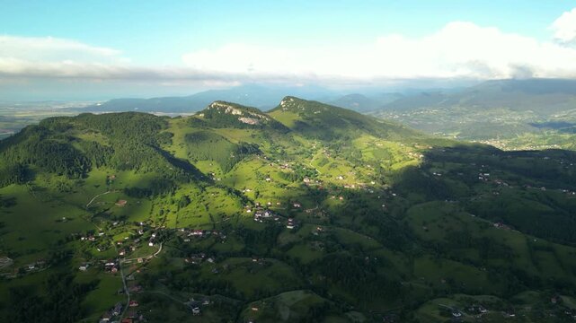 High angle flyover footage over the magnificent picturesque village of Magura in Brasov region of the Romanian Carpati mountains. Drone shot of the gem of romanian tourism on a green summer day.
