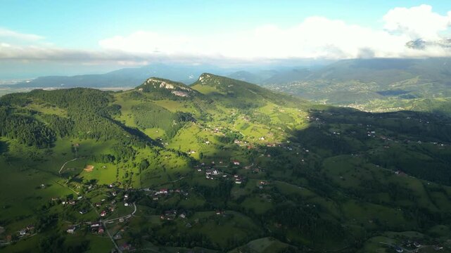 High angle flyover footage over the magnificent picturesque village of Magura in Brasov region of the Romanian Carpati mountains. Drone shot of the gem of romanian tourism on a green summer day.
