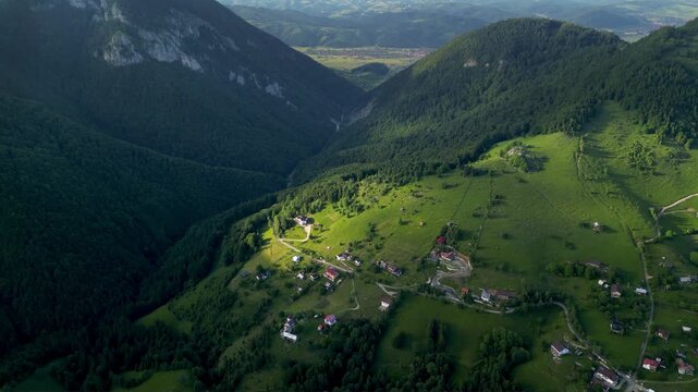 High angle flyover footage over the magnificent picturesque village of Magura in Brasov region of the Romanian Carpati mountains. Drone shot of the gem of romanian tourism on a green summer day.
