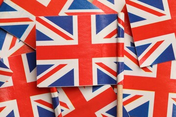 Small paper flags of United Kingdom as background, top view