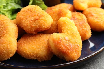 Tasty chicken nuggets on grey table, closeup