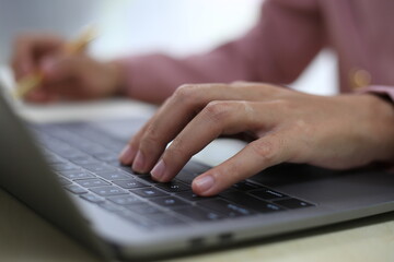 Successful Asian businesswoman sitting at desk working using laptop computer in office. Business and people concept. Businesswoman using laptop computer and working with documents.