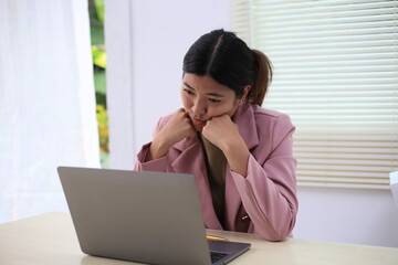 Successful Asian businesswoman sitting at desk working using laptop computer in office. Business and people concept. Businesswoman using laptop computer and working with documents.