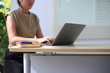 Successful Asian businesswoman sitting at desk working using laptop computer in office. Business and people concept. Businesswoman using laptop computer and working with documents.