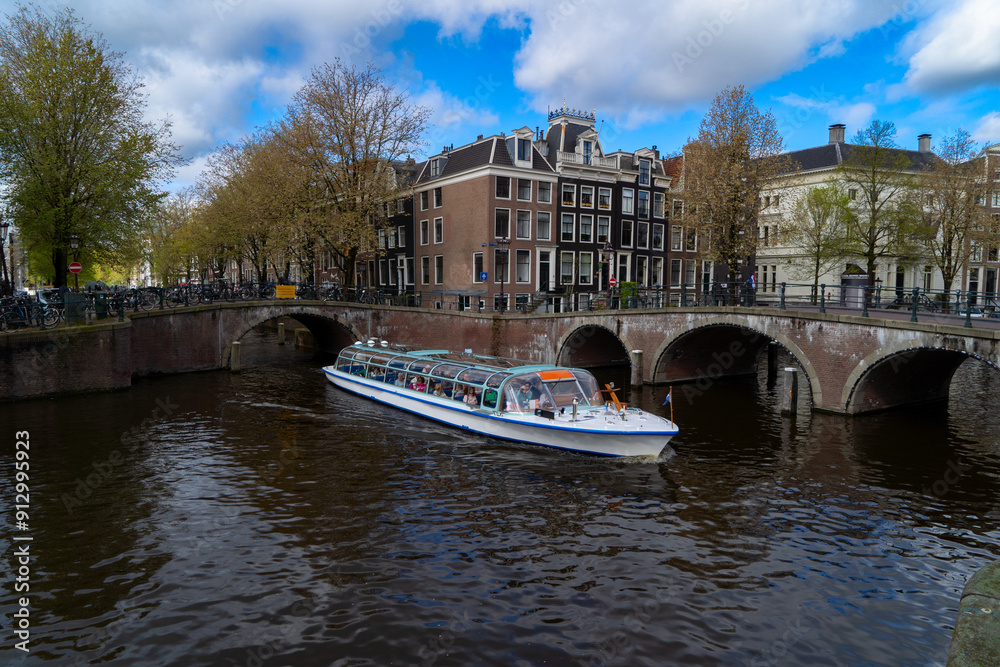 Wall mural moored boats and facades of old historic houses over canal water, amsterdam, netherlands