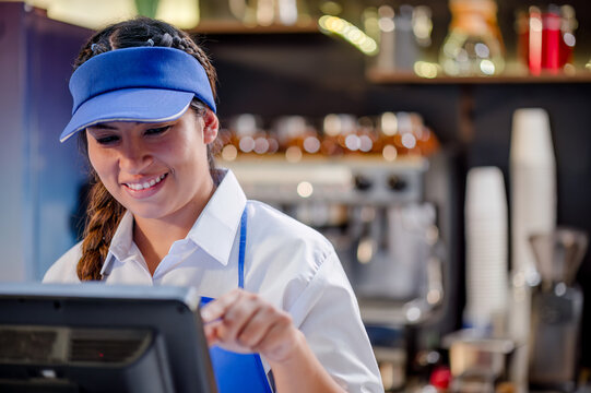 Close-up shot of a Latina woman working as a cashier at a fast food restaurant.