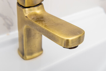 Rusty deposits of hard water on golden sink faucet. Plaque stains