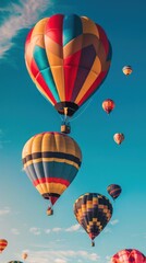 Fototapeta premium Colorful hot air balloons soar in a blue sky.