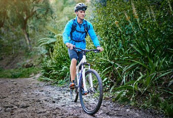 Fototapeta premium Man, bicycle and mountain terrain for fitness in outdoor, performance and extreme sports. Male person, athlete and training in nature for triathlon, forest and riding exercise for cardio challenge