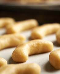 Raw vanilla crescents or Kipferl, traditional Christmas cookies, on a baking paper