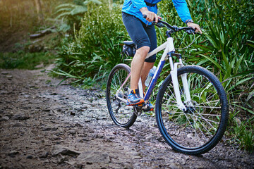 Naklejka premium Person, legs and forest for cycling adventure in outdoor, performance and mountain for extreme sports. Footwear, athlete and training in nature for triathlon, fitness and riding exercise on trail