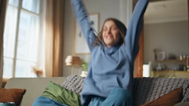 Joyful woman playing video game sitting living room couch closeup. Excited girl 