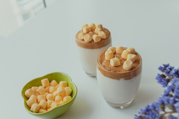 Dalgona coffee with marshmallows, whipped coffee with fluffy topping, and elegant presentation on white table