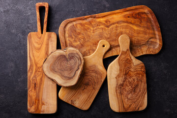 Cutting boards assortment made of olive wood. Grey background. Top view.