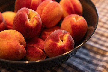 Pêches  🍑 dans un bol sur tissus quadrillé , horizontal
