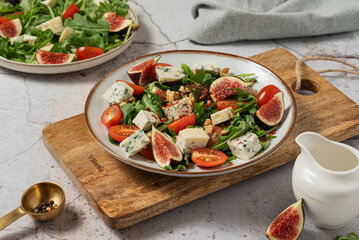 salad with figs, rucola and walnuts. salad with rucola. salad on a light background. salad with blue cheese.
