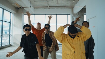 Closeup image of multicultural energetic hipster group dance together. Street dancer team with colorful outfit stretch arms and dancing to hip-hop music. Break dance. Outdoor music 2024. Hiphop.