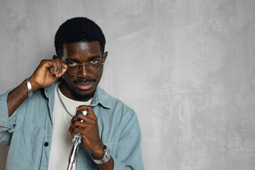 Man singing hit with open mouth in retro microphone. Portrait of handsome attractive african american singer on grey background studio