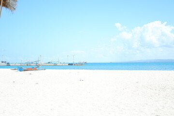 Quiet Beach with Traditional Boat and Clear Blue Waters