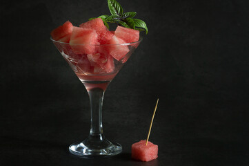 watermelon cocktail with ice and mint on a black background. summer drink.