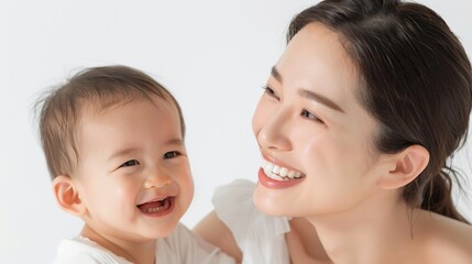 Warm and tender moment between an Asian mother and her beaming baby, captured in a bright studio.