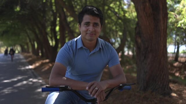 Portrait of a mexican man posing with a bicycle outdoors