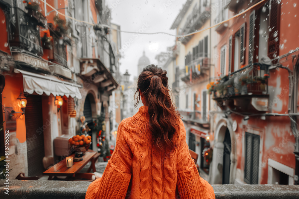 Sticker Brunette woman in autumn warm orange cardigan against the background of the city. Back view