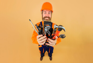 Metallic tools for industrial repair. Building industry. Male builder, mechanic or engineer in protective hard hat with with different tools for building. Selective focus. Advertising for tool store.