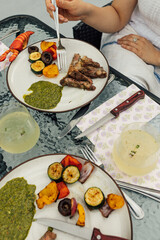 eating a steak dinner with chimichurri and grilled veggies