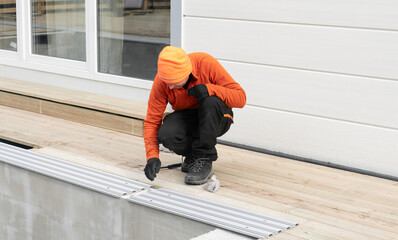 A Skilled Worker Installing Pool Decking with Exceptional Precision and Carefulness Today