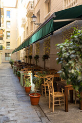 Outdoor street cafe tables ready for service. Empty cafe terrace with wooden tables and chairs, morning time. Food concept