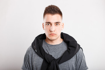 Stylish handsome young man with hairstyle in fashion clothes on white background in studio