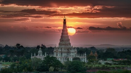 A beautiful sunset over a city with a large white building in the background