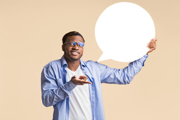 Confused African American Man Holding Blank Speech Bubble Showing What He Really Thinks Standing Over Yellow Background. Mockup