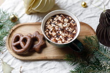 Christmas background. Cup of hot chocolate with marshmallow and cookies, christmas ornaments and gift on wooden tray top view. Merry Christmas. Winter hygge