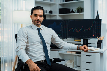 Profile of successful in trader businessman looking at camera with two stock exchange investment screens with good-looking pose in dynamic financial technology graph stock market at office. Surmise.