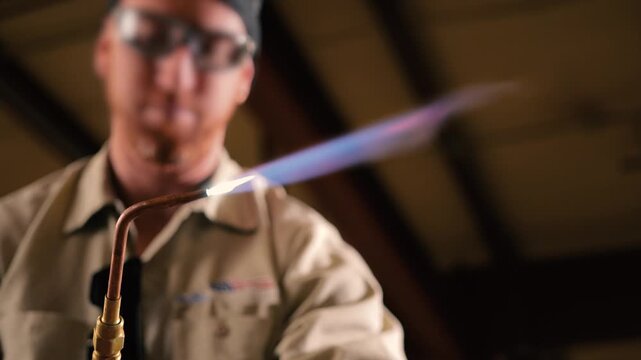 Pipefitter examining an oxyacetylene torch for brazing