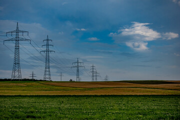 Regen und Gewitterwolken über Strommasten