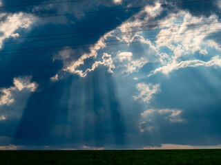 Sonne bricht durch dunklen Wolkenhimmel